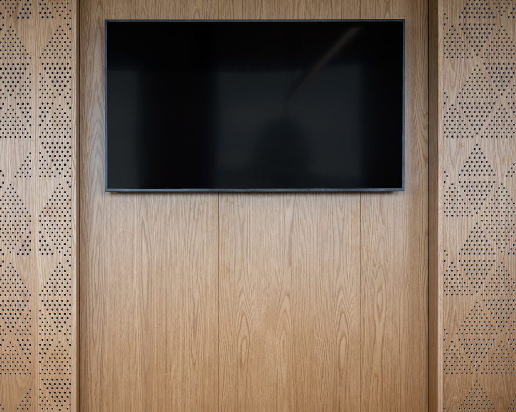 TV in niche with bespoke panels on the wall