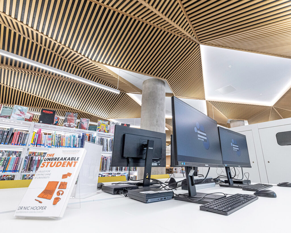 Computers in front of diamond patterned ceiling