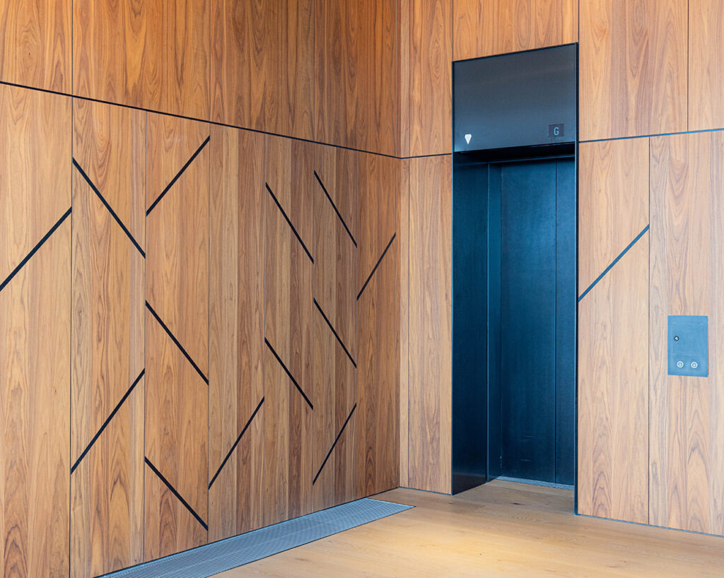Custom-made walnut panels by elevator
